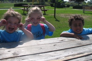 Smiling kids on picnic tables